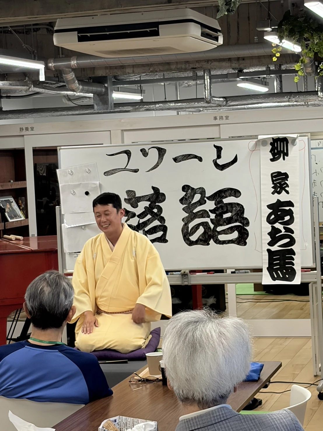着物姿の落語家と、後ろ姿で聞く利用者様